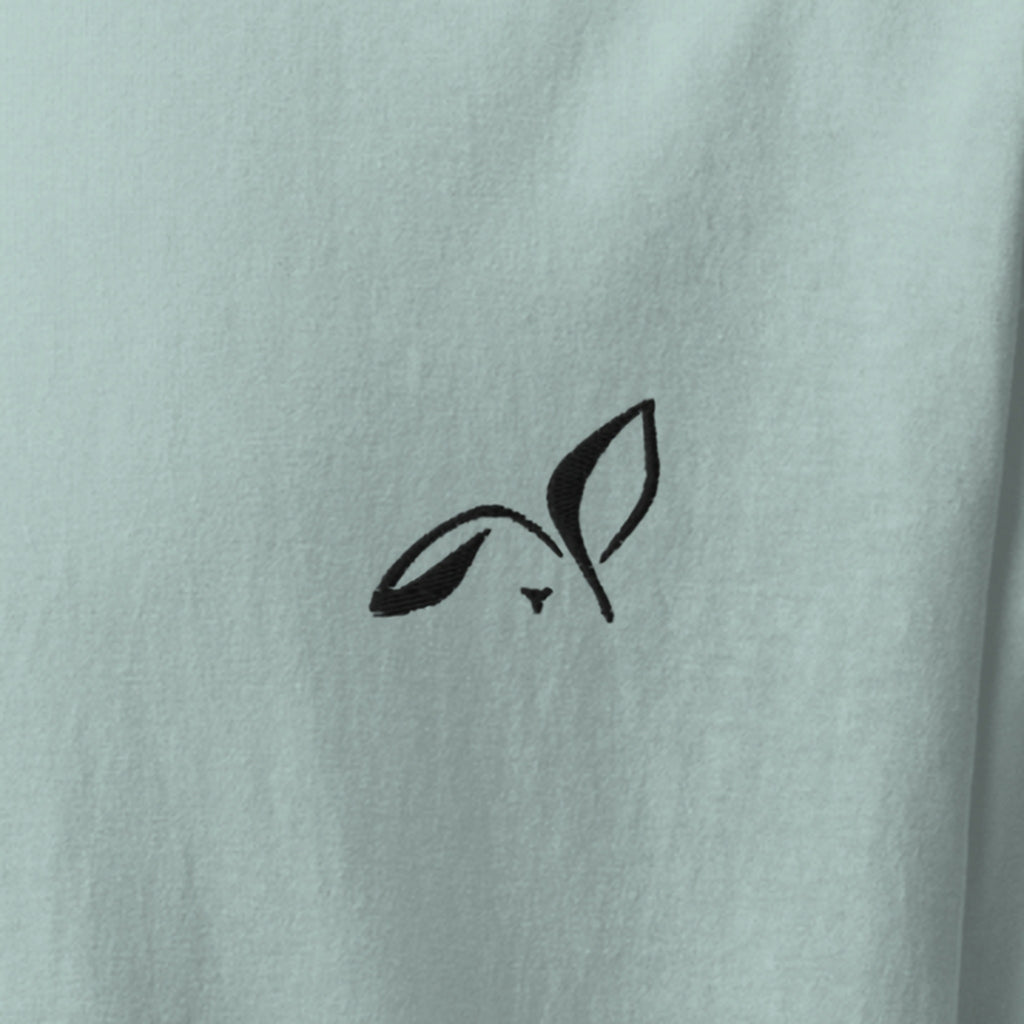 Close-up of the black embroidered LOUPI GANG rabbit on the left chest of the Agave Fine Print Tee.