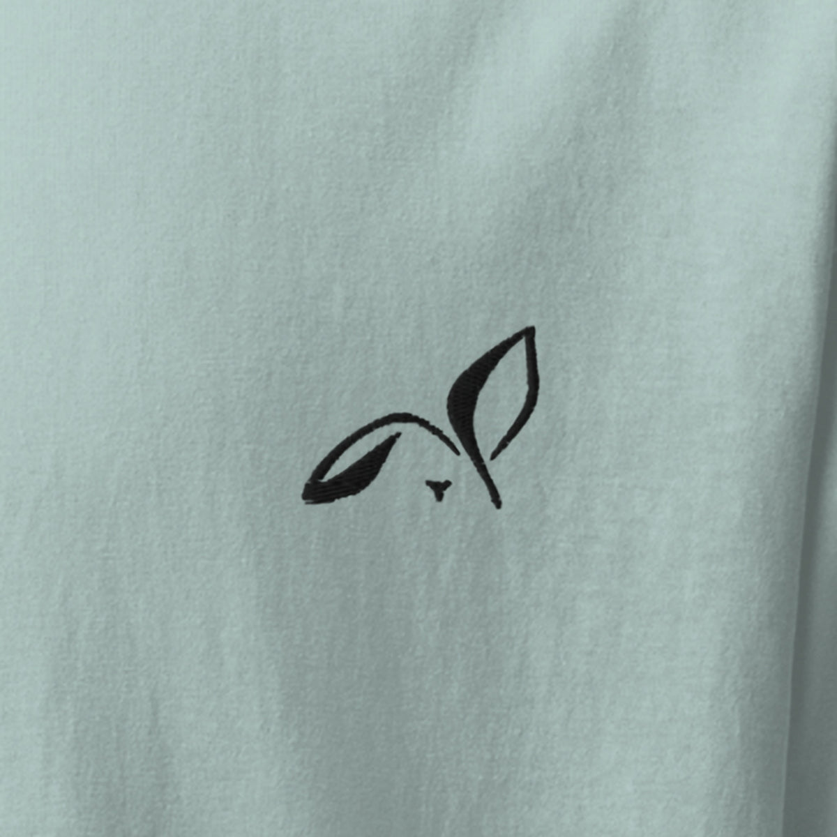 Close-up of the black embroidered LOUPI GANG rabbit on the left chest of the Agave Fine Print Tee.