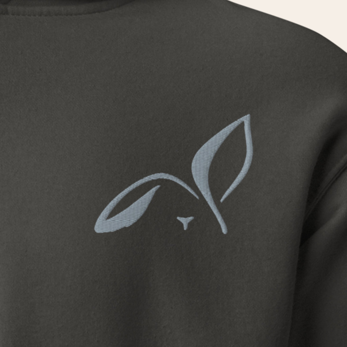 Close-up of the grey embroidered LOUPI GANG rabbit on the left chest of the Vintage Black Noticed Later Hoodie.