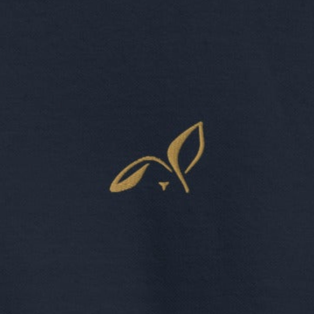 Close-up of the Old Gold embroidered LOUPI GANG rabbit on the left chest of the navy Off The Record Crew.