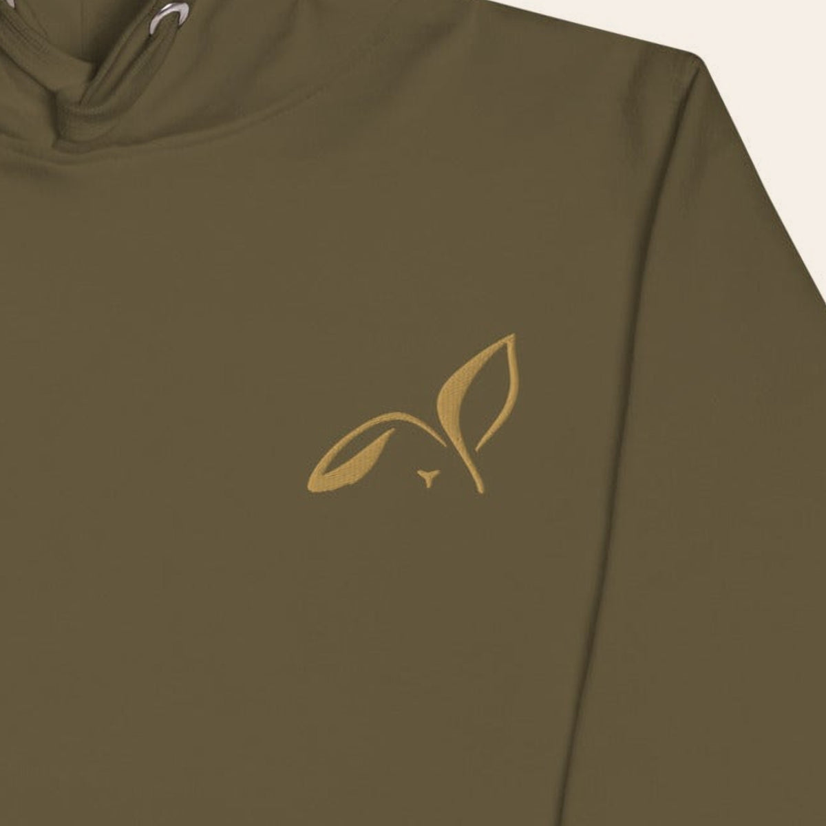 Close-up of the Old Gold embroidered LOUPI GANG rabbit on the left chest of the Military Green Second Look Hoodie.