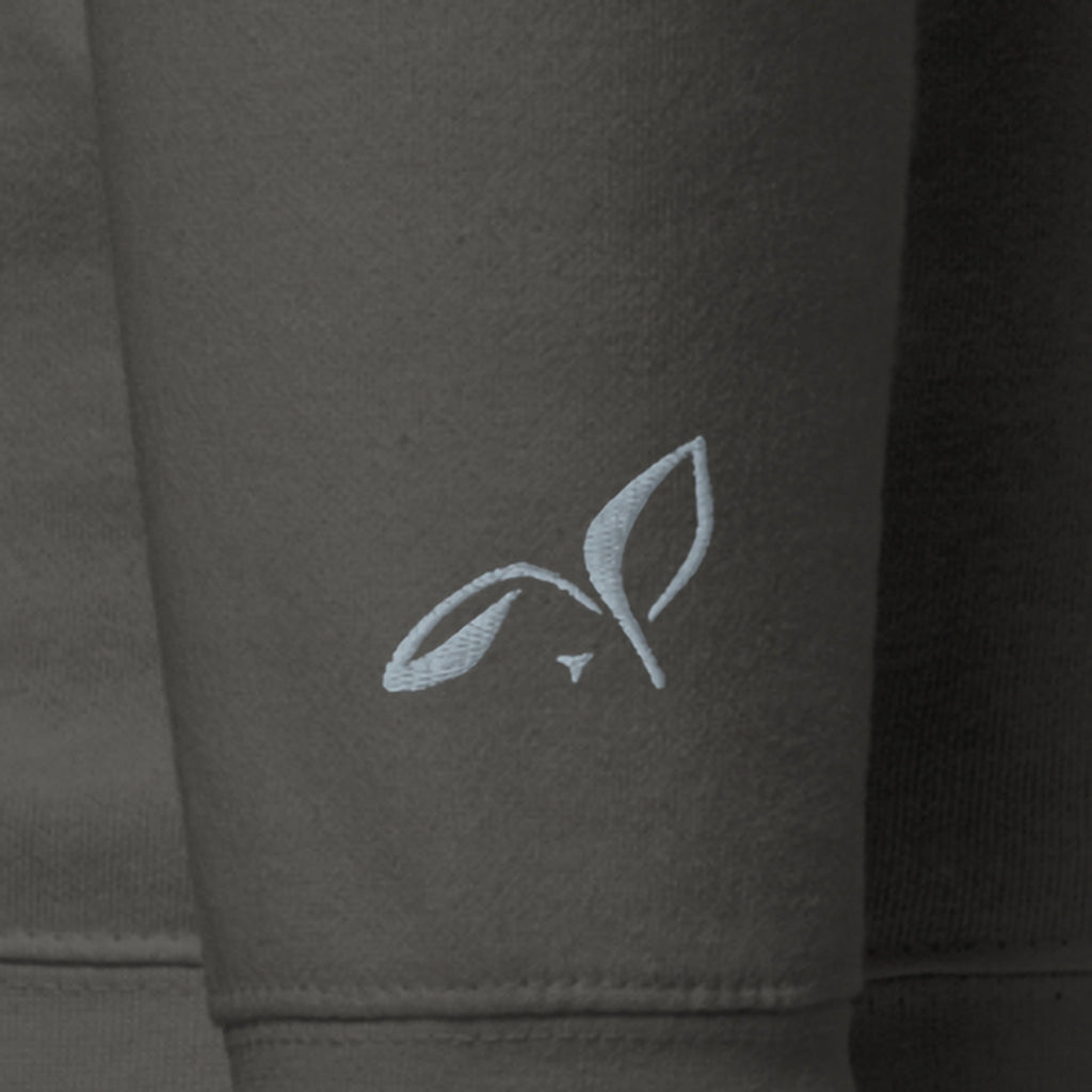 Close-up of the right wrist of the Noticed Later Hoodie, a small LOUPI GANG rabbit embroidered in grey thread above the cuff.