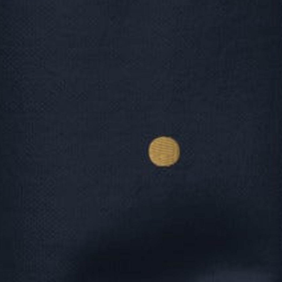 Close-up of the left wrist of the Off The Record Crew, a single gold full stop embroidered in Old Gold thread.