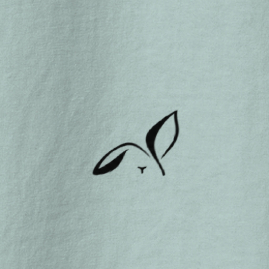 Close-up of the small black LOUPI GANG rabbit printed on the back of the Agave Fine Print Tee.