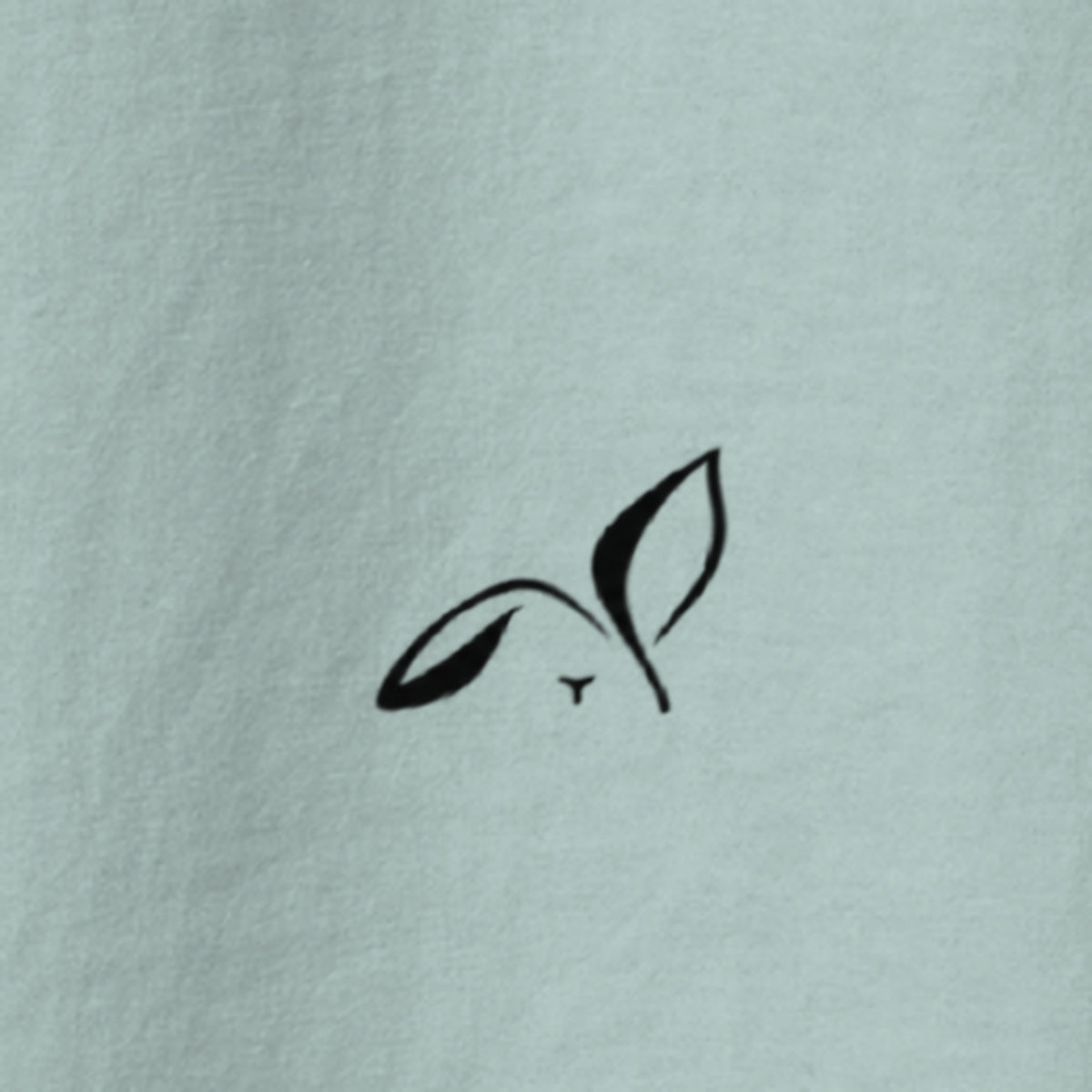Close-up of the small black LOUPI GANG rabbit printed on the back of the Agave Fine Print Tee.