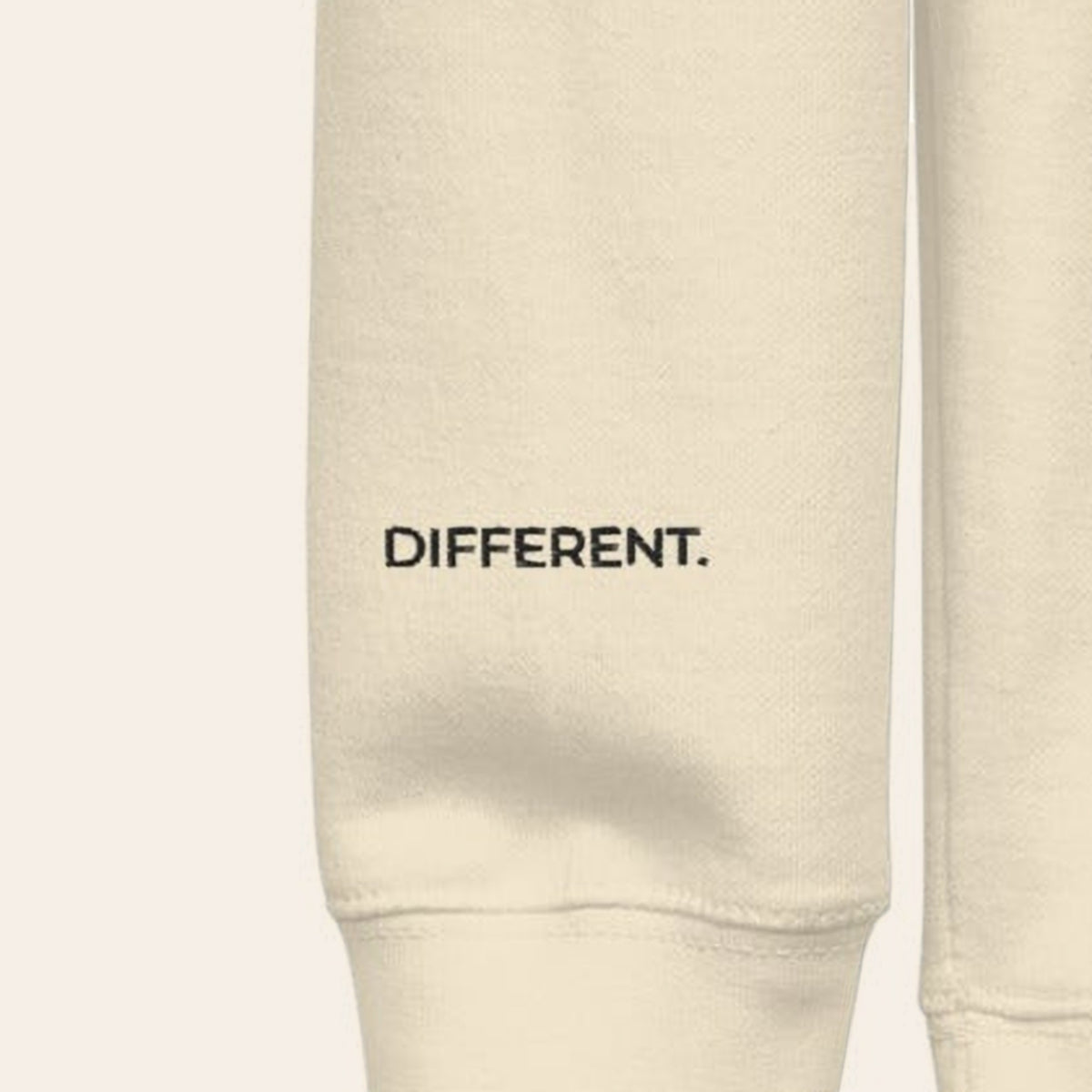 Close-up of the right cuff of the Morning Edition Crew, embroidered DIFFERENT. in black thread.