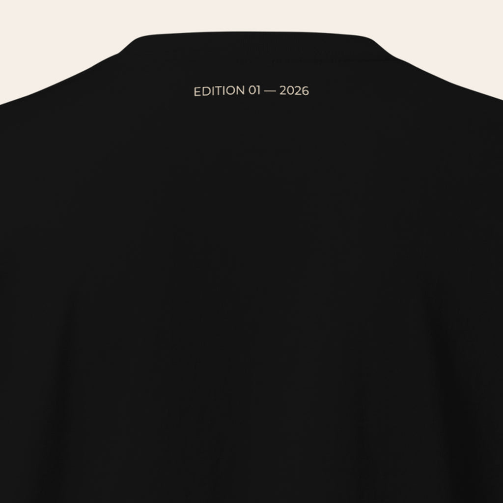 LOUPI GANG Signature Heavyweight Tee in Black, back neck with sand EDITION 01 — 2026 print below the collar